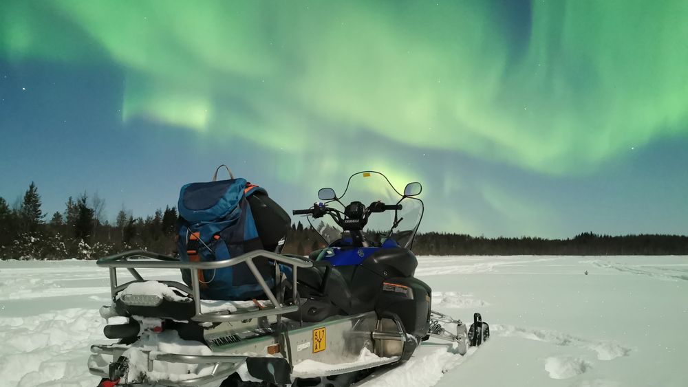 Northern lights by snowmobile